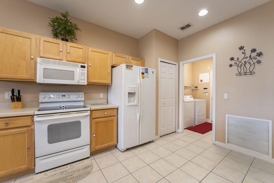 Kitchen with full appliances and adjacent laundry area.