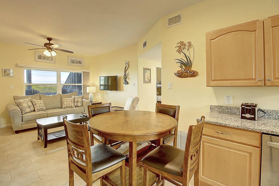 Gather around your dining table for memorable meals, then unwind in the cozy living area with warm coastal charm.