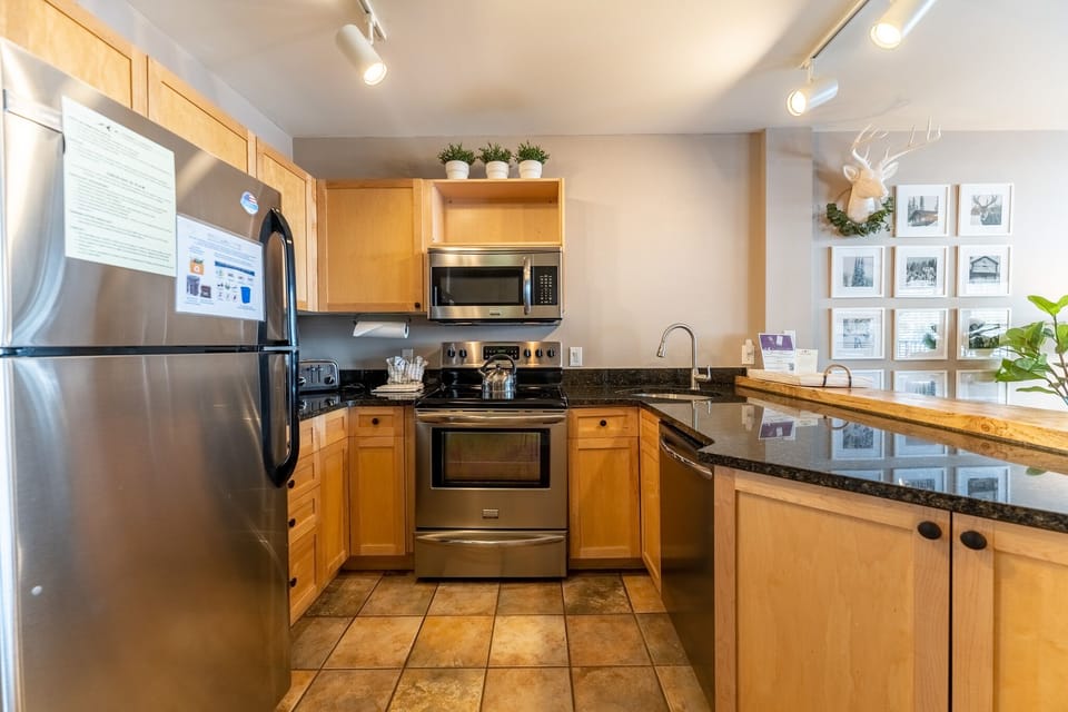 Your fully equipped kitchen invites culinary adventures with granite counters, stainless appliances, and warm wood cabinetry creating the perfect cooking sanctuary.