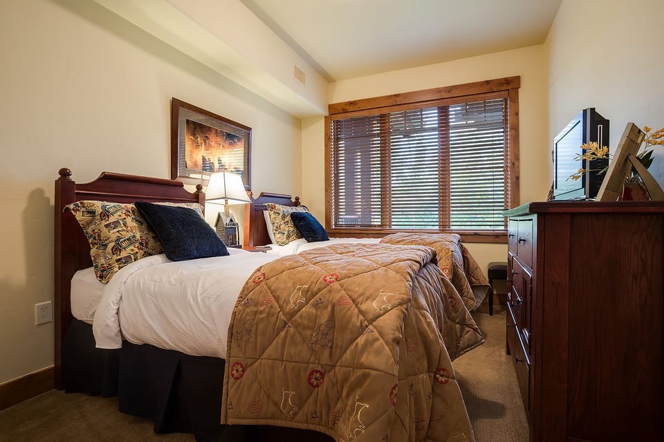 Sink into plush bedding and enjoy your private retreat with rich wood furnishings, thoughtful decor, and natural light filtering through.