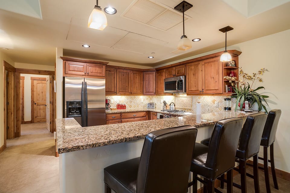 Your gourmet kitchen awaits with granite counters, stainless steel appliances, and a breakfast bar where you'll savor morning coffee together.