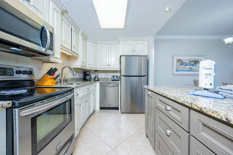 Prepare meals in the inviting kitchen featuring granite counters, stainless appliances, and elegant cabinetry