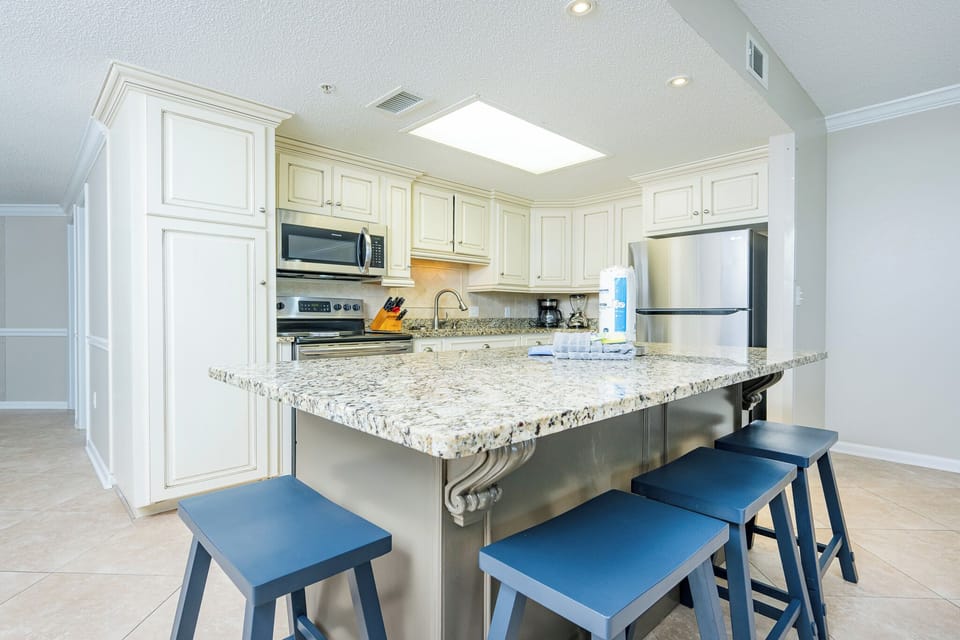 Inviting kitchen space with granite countertops, stainless appliances, and open design with an island