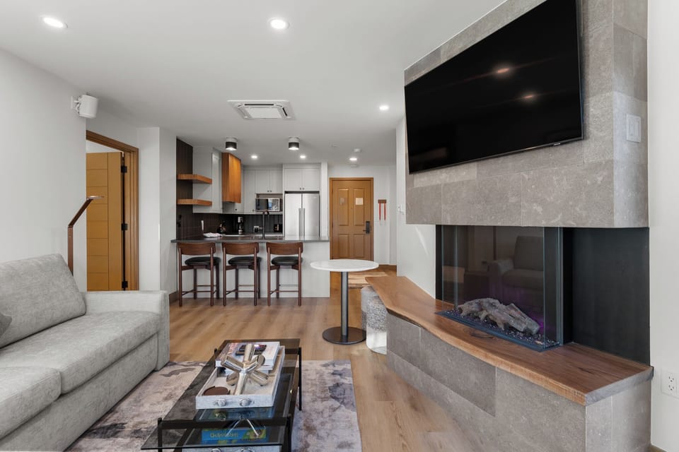 Unwind by your modern fireplace while enjoying the open kitchen and stylish living area designed for your comfort.