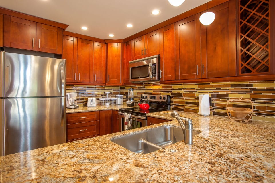 Your fully equipped kitchen features rich wood cabinetry, gleaming granite counters, and stainless appliances, making it easy to whip up anything from coffee to full family meals.