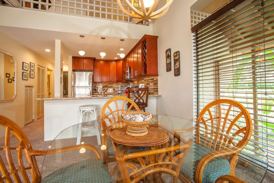 A bright, open-concept space with a charming glass dining table and a fully equipped kitchen ready for your culinary adventures and shared meals.