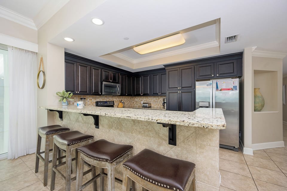 Gather around the sleek bar area with comfortable stools, perfect for casual meals and conversation during your stay