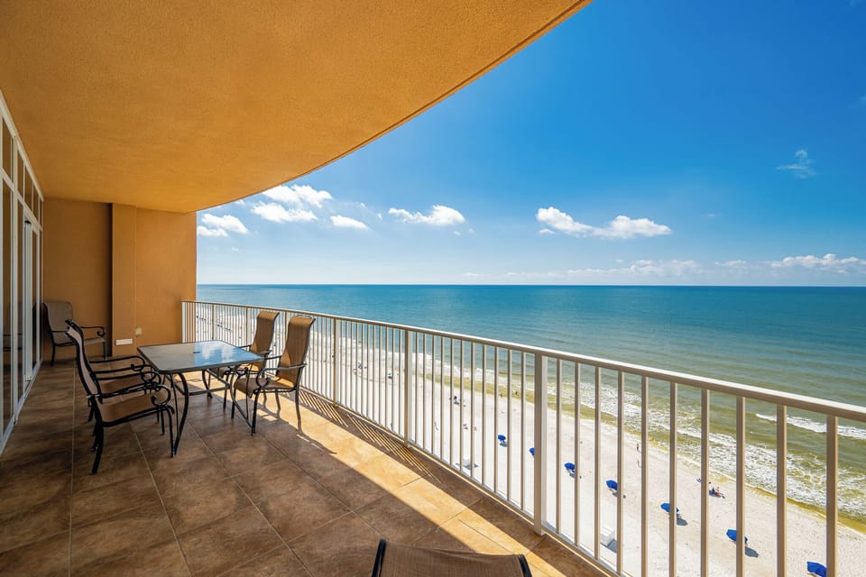 Relax on the spacious balcony, enjoying the expansive view of the stunning shoreline below