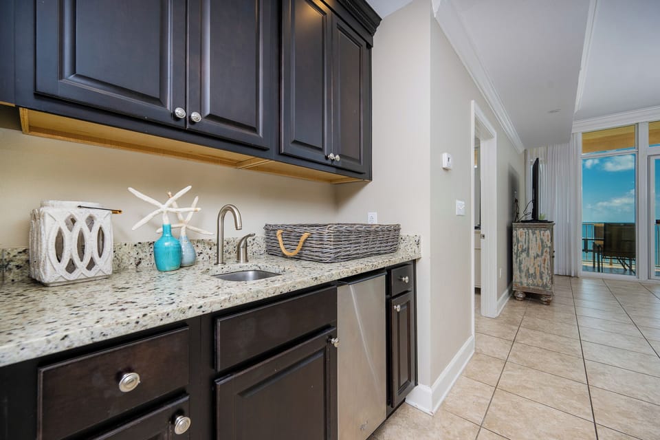 Enjoy preparing snacks at the stylish wet bar with charming coastal decor and an ice maker