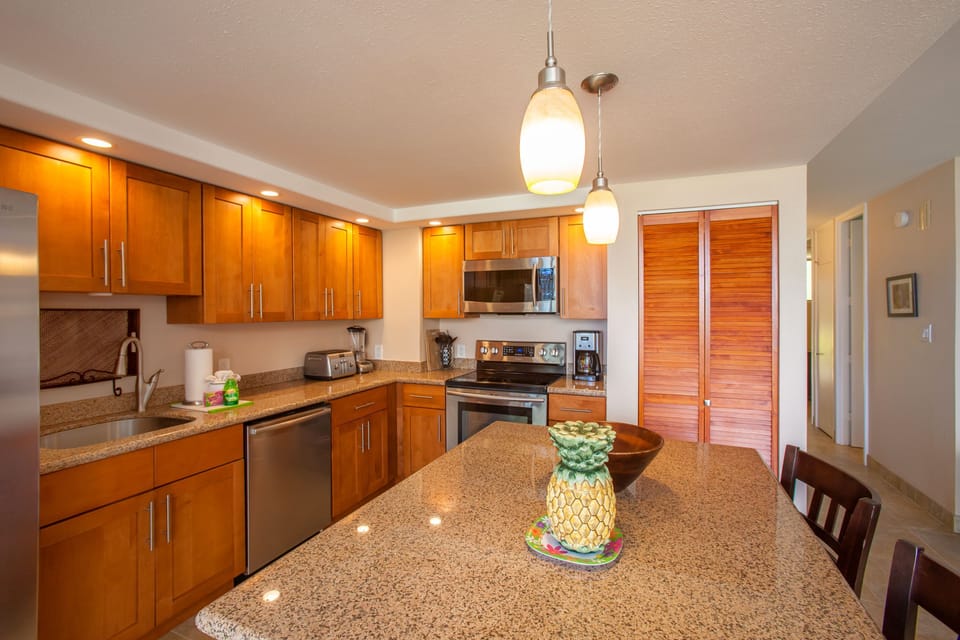 Your fully equipped kitchen invites you to prepare meals with ease, featuring warm wood cabinetry, granite countertops, stainless steel appliances, and a welcoming island for dining and gathering.