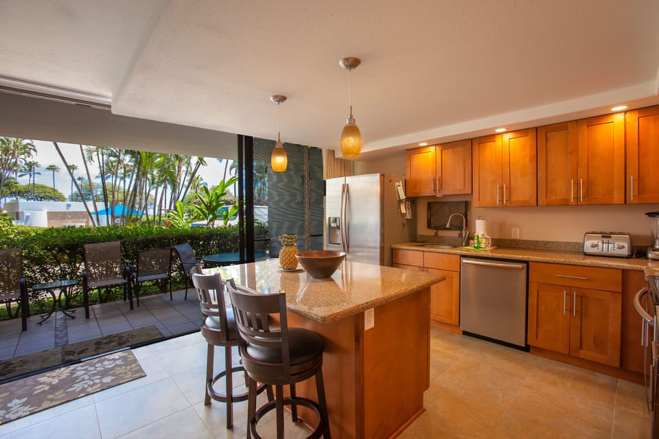 Your fully-equipped kitchen opens to a private patio with garden views, perfect for morning coffee or preparing island-inspired meals while enjoying tropical breezes.