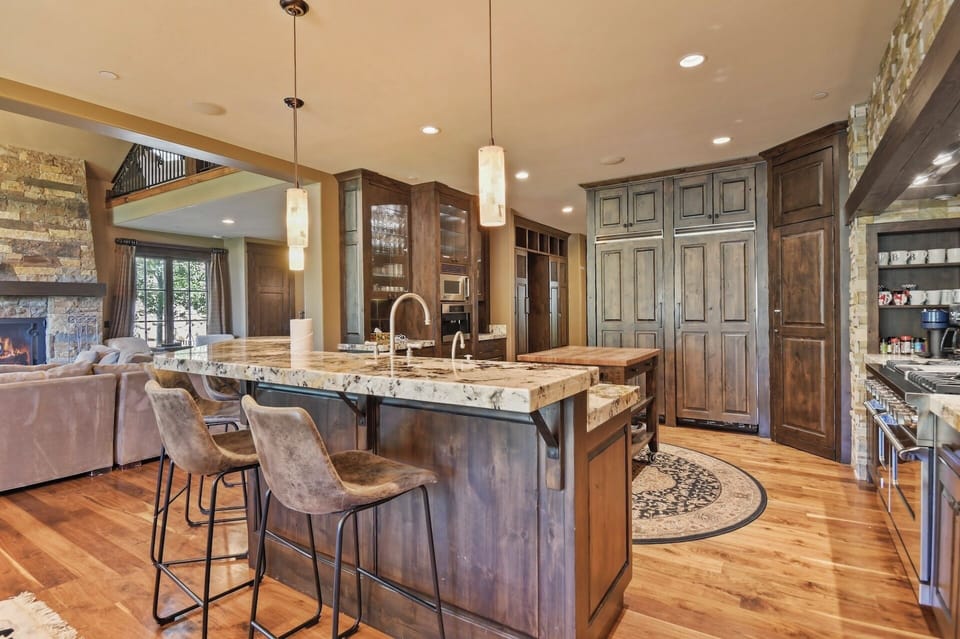 Gather around the stunning granite island in your spacious, chef-ready kitchen, where warm wood tones and stone accents create a welcoming heart for your mountain retreat.