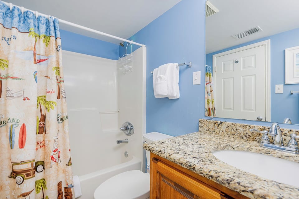 Blue walls brighten the guest bath where you refresh and towel off after a day of outdoor fun