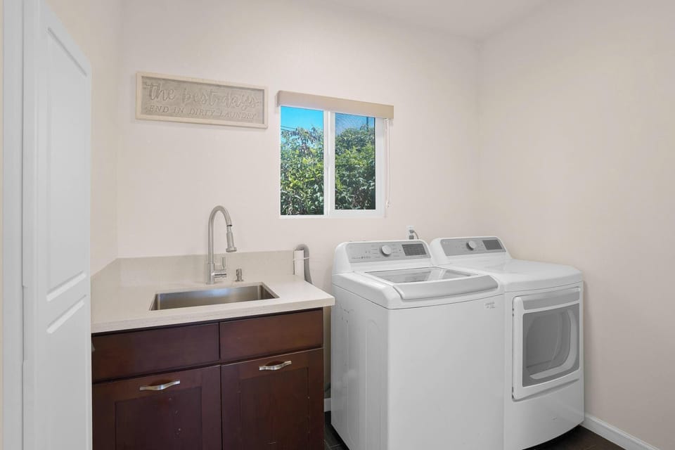 Laundry room w/ utility sink, steam dryer & detergent. 