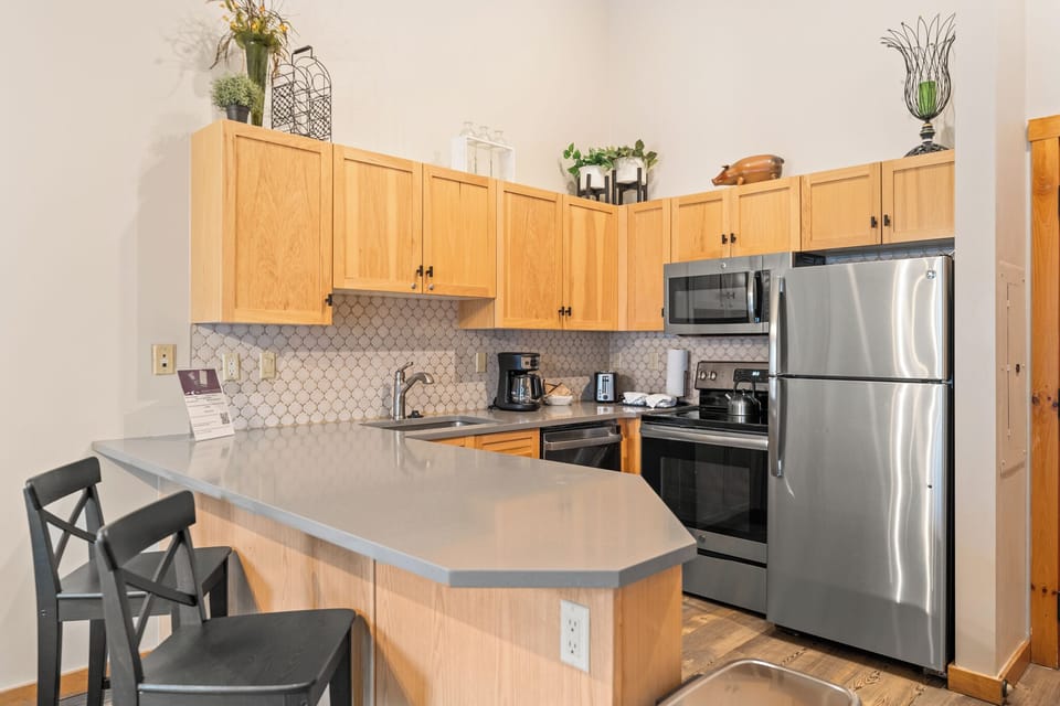 Your fully equipped kitchen features modern appliances and a breakfast bar where you can sip morning coffee while planning adventures.