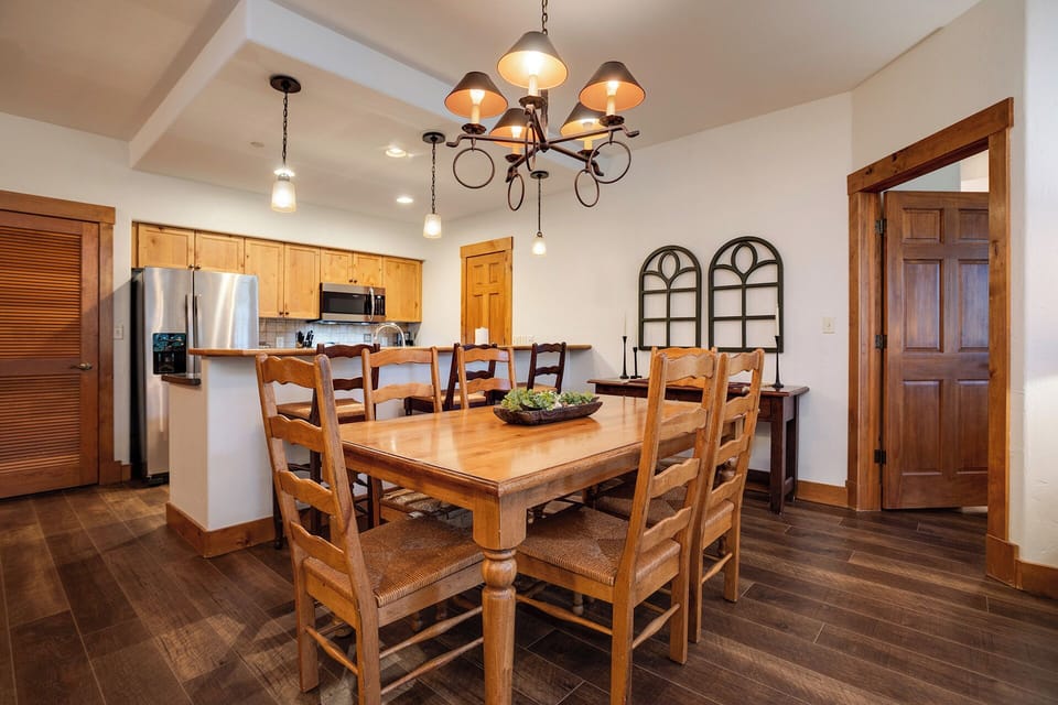 Gather around your rustic dining table for memorable meals, with warm wood tones and elegant chandelier creating the perfect atmosphere for connection.