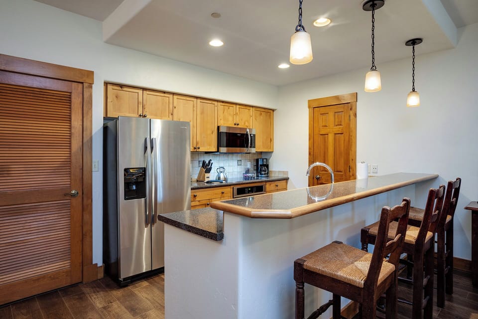Your fully equipped kitchen features granite counters, stainless appliances, and a breakfast bar where you can savor morning coffee.