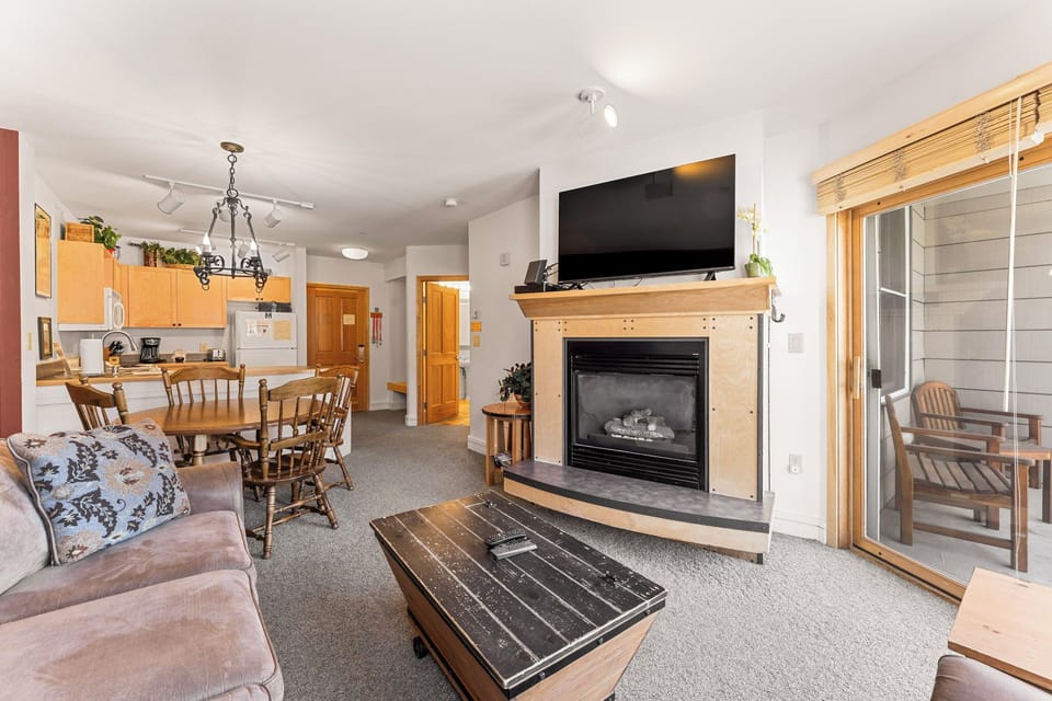 Cozy up in your open-concept space where the living room flows into the kitchen, with a warm fireplace and balcony access perfect for morning coffee.