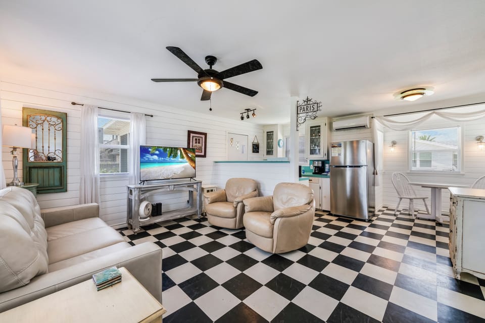 Step into your cozy retreat with charming checkered floors, plush seating, and a fully-equipped kitchen ready for your vacation meals and relaxation.