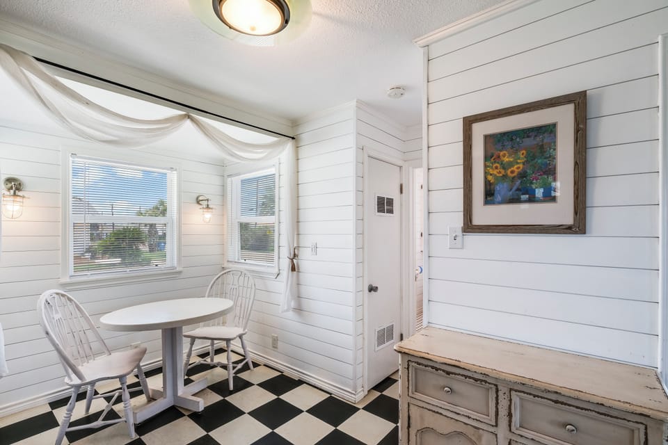 This charming dining nook offers a cozy spot to enjoy your morning coffee or plan the day ahead at the quaint round table, framed by soft natural light.