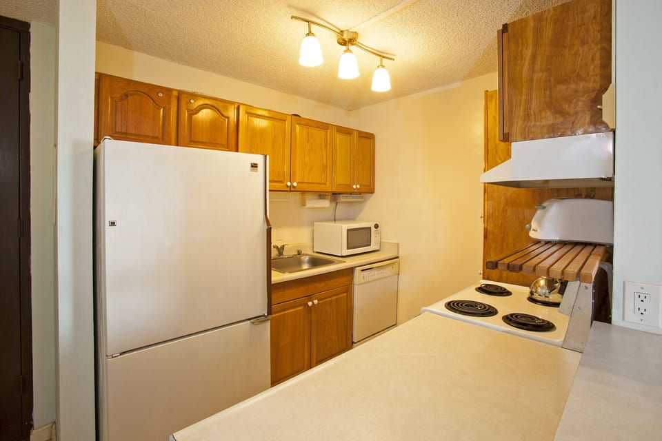 Your fully equipped kitchen awaits with warm wood cabinetry, modern appliances, and plenty of counter space to prepare home-cooked meals during your stay.