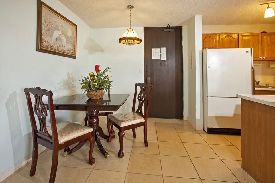 A welcoming dining area with elegant furniture and a well-equipped kitchen awaits you, perfect for enjoying meals together during your stay.