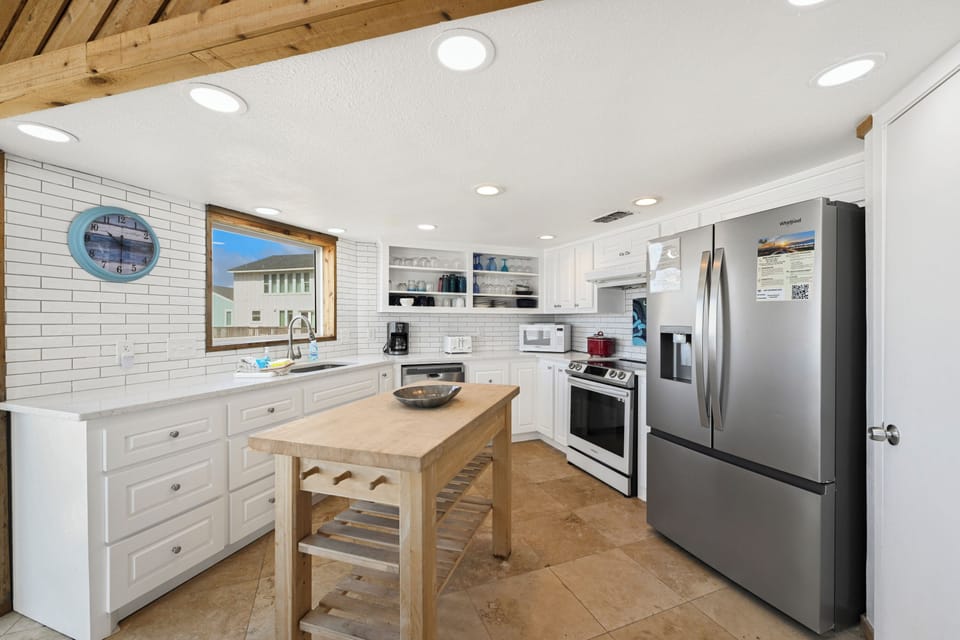 Your fully equipped kitchen features modern appliances, ample counter space, and a charming island—perfect for preparing meals or enjoying morning coffee together.