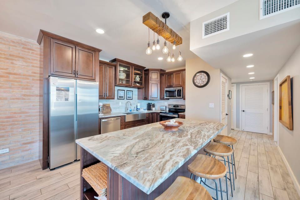 Your spacious kitchen features rich wood cabinetry, granite countertops, and a stunning pendant light fixture perfect for cooking memorable meals.
