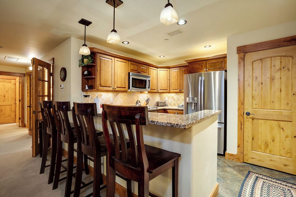 Your spacious kitchen features granite counters, stainless steel appliances, and a breakfast bar perfect for morning coffee and casual meals.