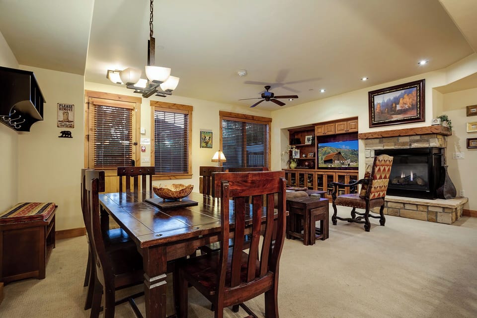 Gather around the handcrafted dining table or unwind by your cozy stone fireplace in this warm, inviting space.