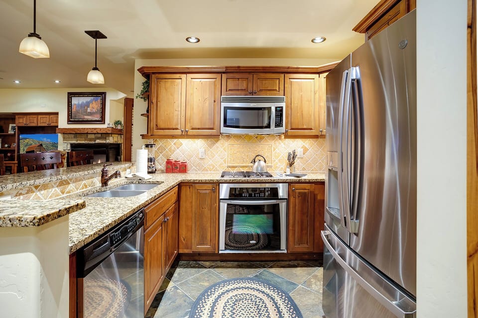 Your gourmet kitchen awaits with granite counters, stainless appliances, and rich wood cabinetry—perfect for preparing memorable meals together.