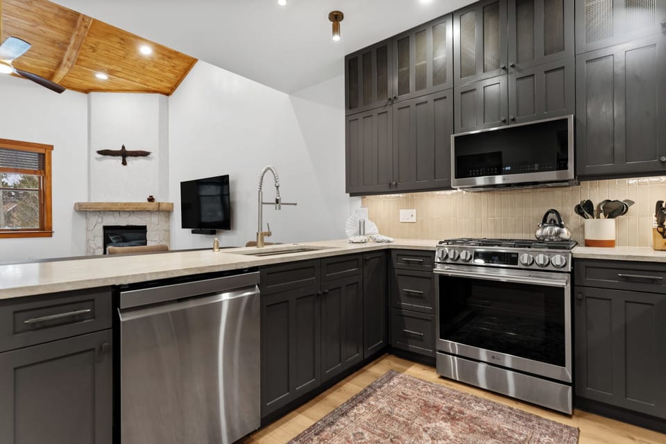 Your sleek kitchen features modern appliances and beautiful wood ceilings, perfect for preparing memorable meals during your stay.