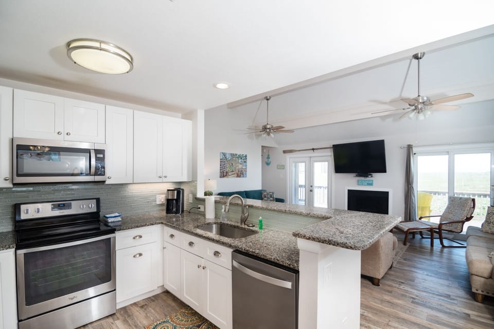 Your spacious kitchen features granite counters and modern appliances, flowing seamlessly into the bright living area.