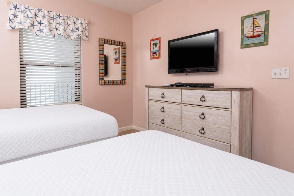 Rest in this cheerful guest room with two double beds, a flat-screen TV, and beach-themed decor for a relaxing getaway