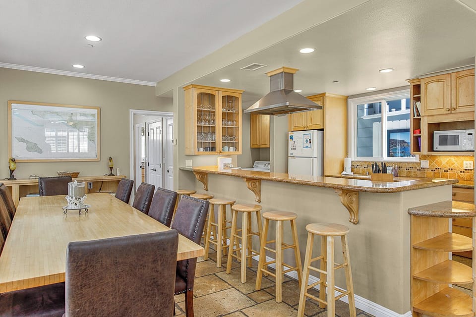 Gather around this spacious kitchen and dining area where cooking becomes a social experience, complete with breakfast bar seating for casual meals.