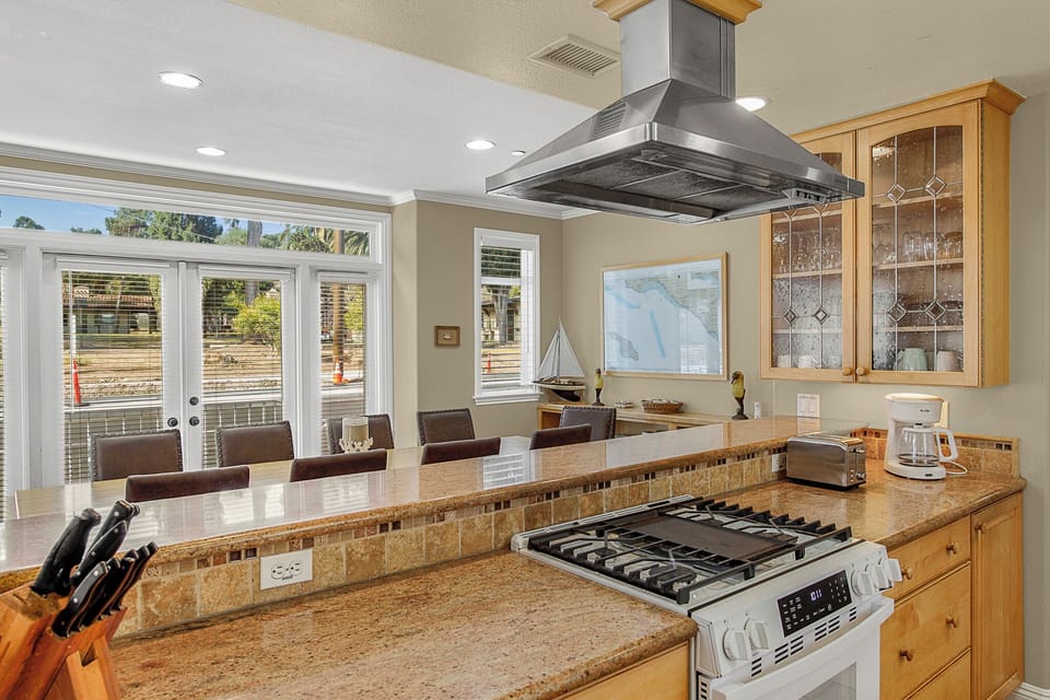Your gourmet kitchen features granite counters and modern appliances, perfect for preparing meals while enjoying garden views.