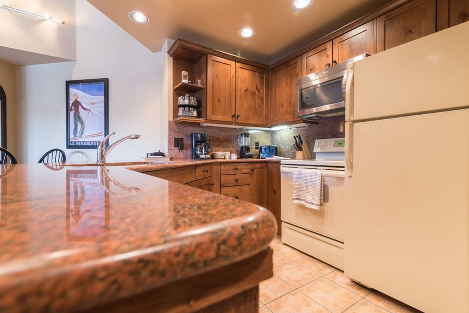 Your fully equipped kitchen features granite counters, warm wood cabinets, and everything needed for memorable meals together.