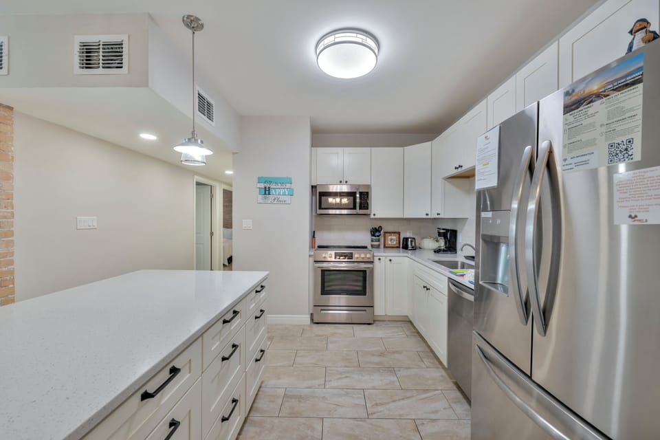 Your spacious kitchen welcomes with white cabinets, gleaming countertops, and modern appliances ready for memorable meals.