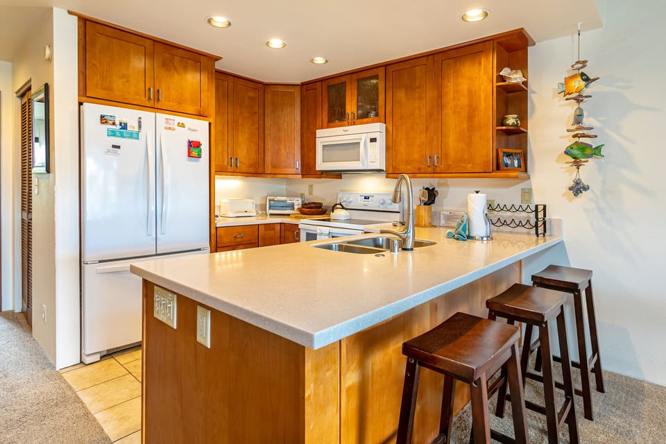 A bright, welcoming kitchen with warm wood cabinetry, stainless appliances, and a spacious island perfect for preparing your favorite meals together.