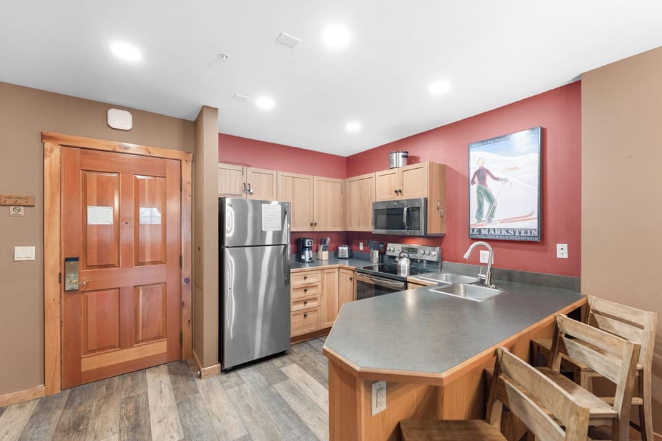 Your fully equipped kitchen features stainless steel appliances, warm wood cabinetry, and granite countertops perfect for preparing meals together.