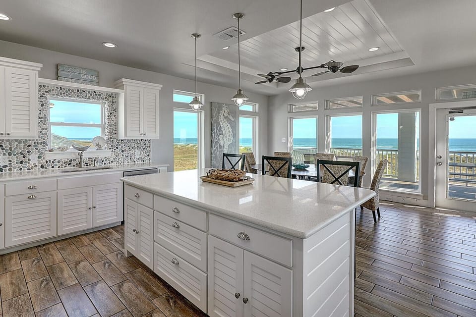 Your bright coastal kitchen offers stunning ocean views while you cook, with spacious counters perfect for preparing meals and sharing stories.