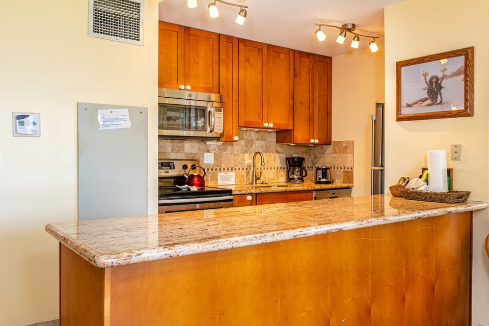 Step into your fully equipped kitchen with granite countertops, warm wood cabinetry, and modern appliances—everything you need to whip up memorable meals during your stay.