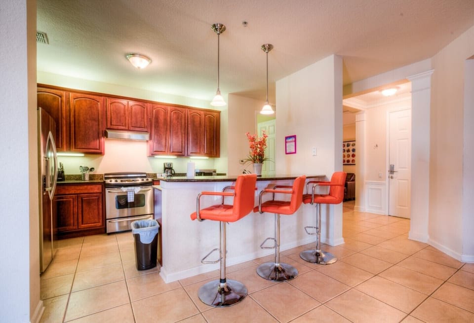 The kitchen is thoughtfully designed with modern appliances and ample counter space, perfect for cooking up culinary delights. Conveniently located in front of the countertop table and high chairs, it's ideal for quick bites or casual dining.