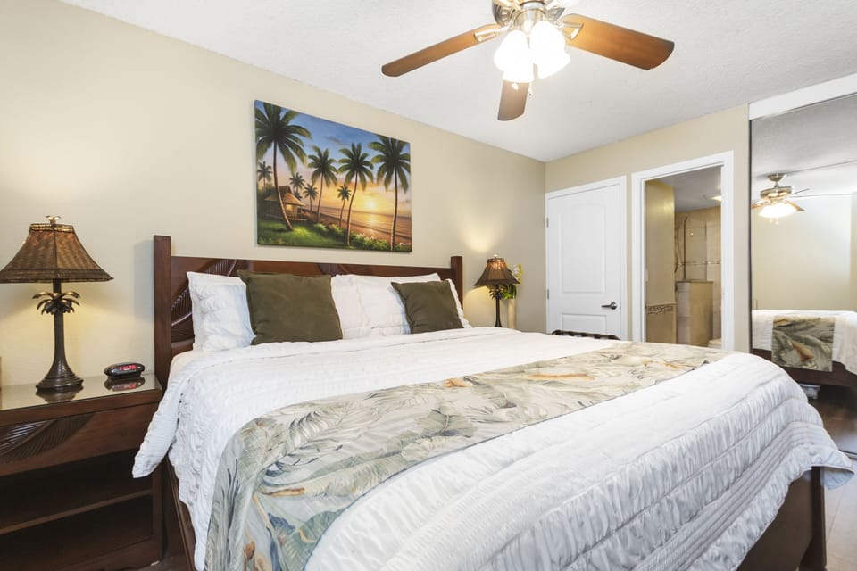 Sink into crisp linens and tropical tranquility in your serene bedroom retreat, where ceiling fans and island-inspired touches create the perfect escape.