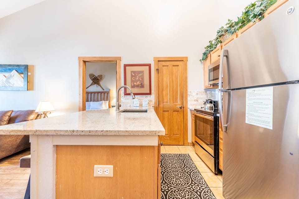 Your fully equipped kitchen features granite countertops, stainless steel appliances, and warm wood cabinetry perfect for preparing memorable meals together.