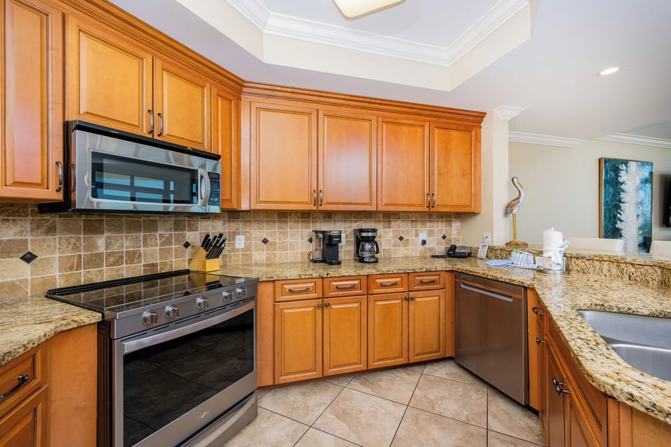 The kitchen features wood cabinetry, stainless appliances, and a convenient coffee maker for a delightful cooking experience