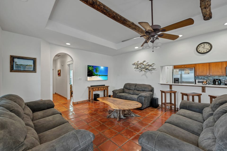 Relax in this spacious open-concept living area with rustic beams, comfy seating, and a fully equipped kitchen perfect for your getaway.