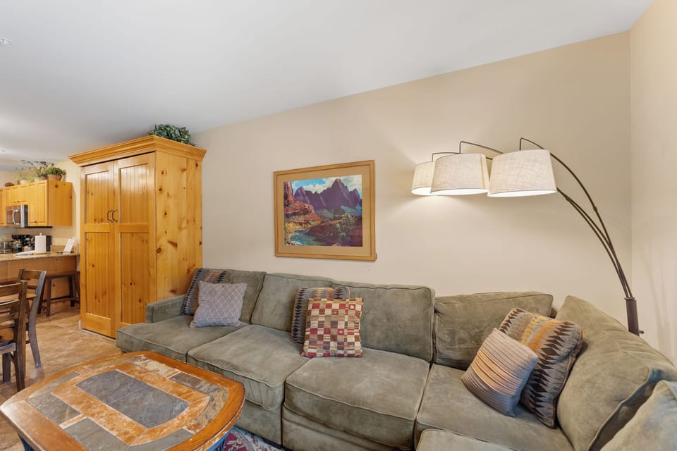 Relax on your plush sectional sofa while mountain art and warm lighting create the perfect atmosphere for unwinding after adventures.