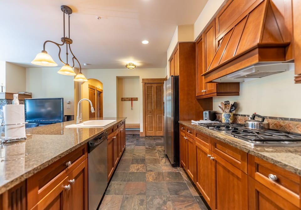 Your fully equipped gourmet kitchen awaits with rich wood cabinetry, granite counters, and modern appliances for memorable meal preparation.