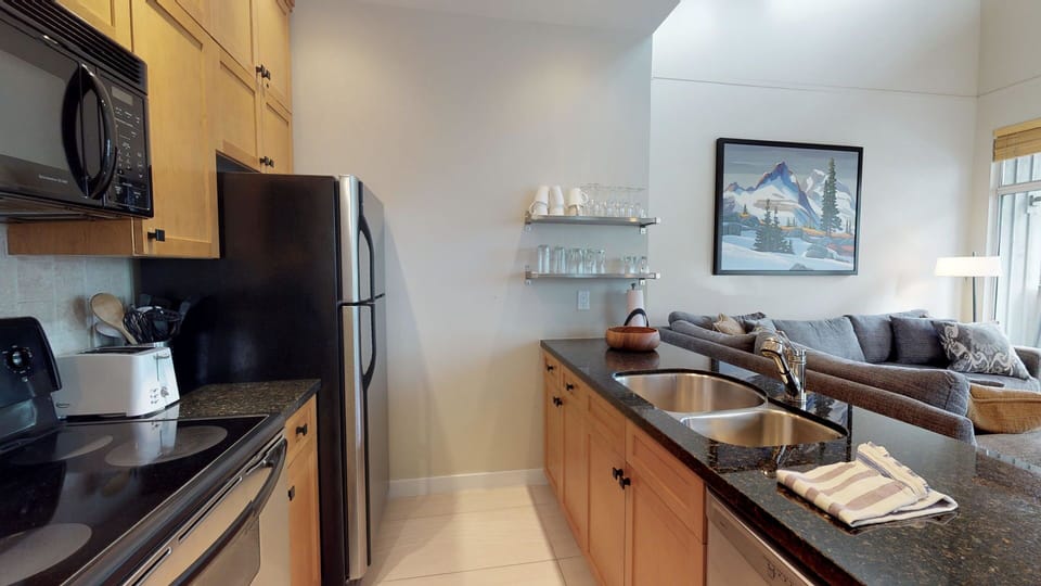 Stone countertops and tile backsplash add a sleek touch to this functional space.